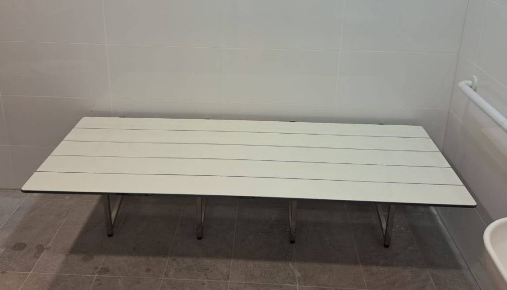 מיטת הלבשה מתקפלת נגישה לנכים - משטח החתלה מתקפל לנכים. עמידות למים, רגליים מנירוסטה, עבור מקלחות נגישות, מלתחות נכים או תא משולב נגיש.